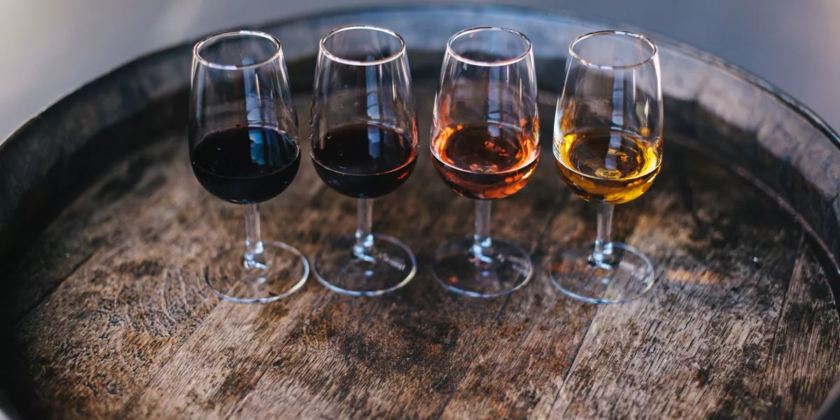 4 port glasses lined up on a barrel for port tasting