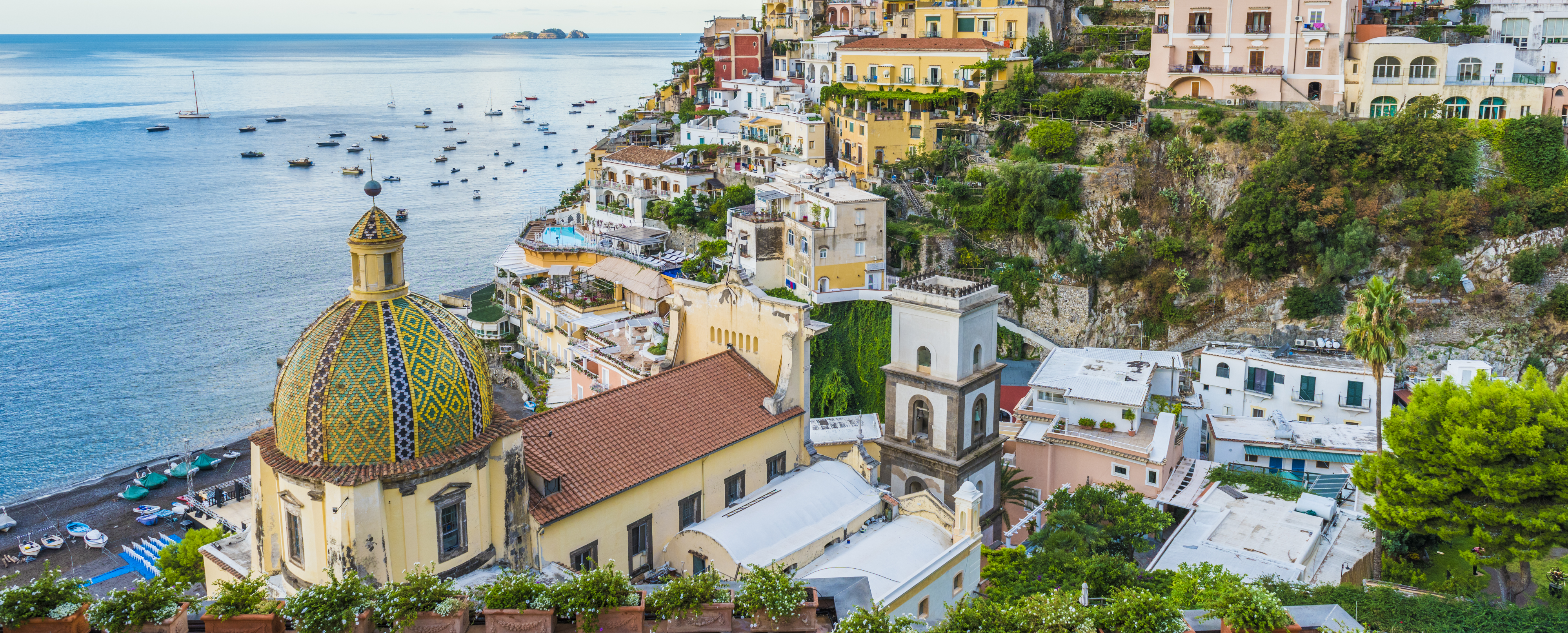 Italian town on a hillside with a colourful dome in the foreground