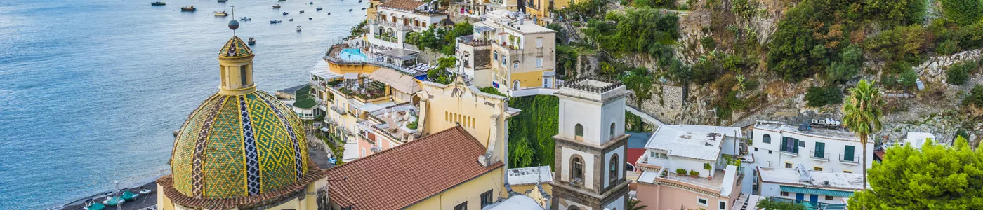 Italian town on a hillside with a colourful dome in the foreground