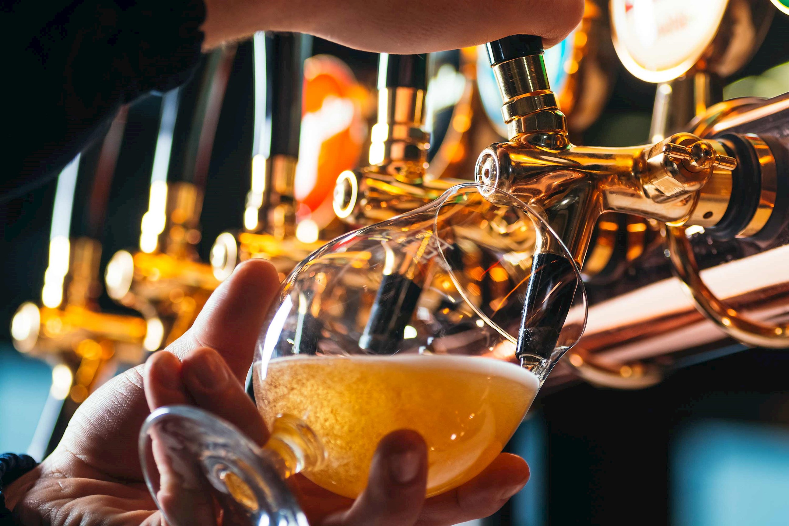 A person pouring a glass of draught beer in Antwerp, Belgium