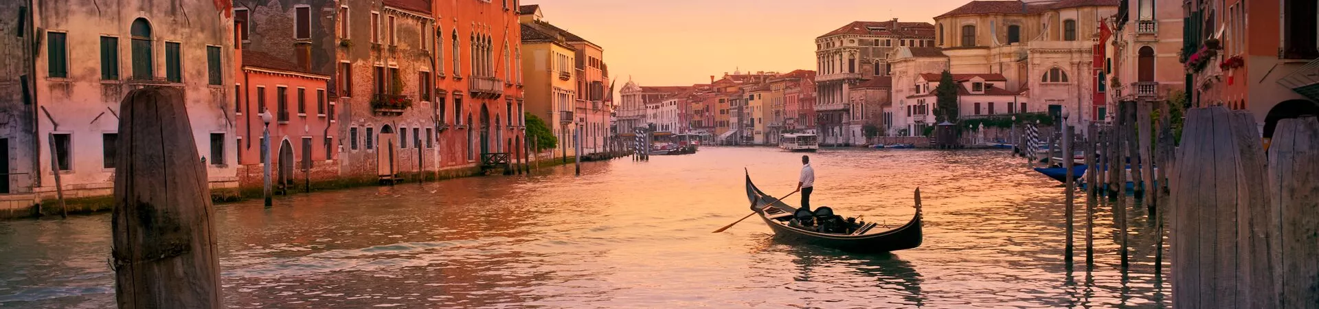 Large Man Rowing Boat In Canal By Buildings 1164329422