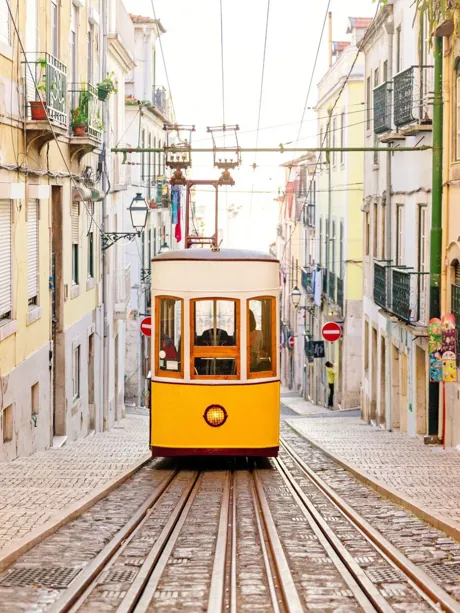 Large Elevador Da Bica Funicular between rows of old traditional houses in Lisbon, Portugal