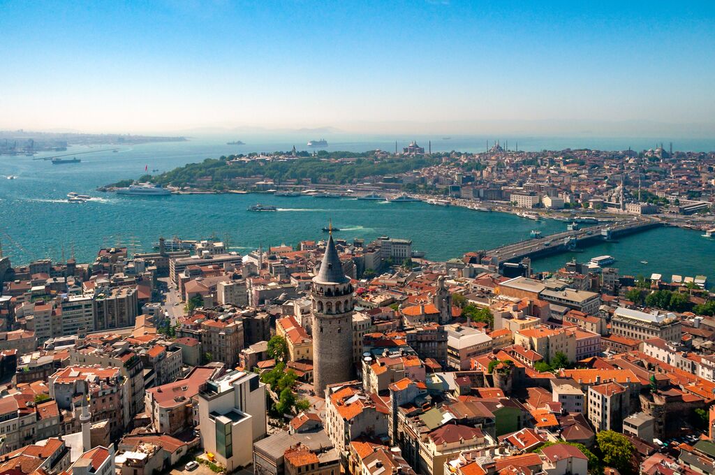 Birds-eye view of Istanbul basking in golden sunlight, a bright blue sky above