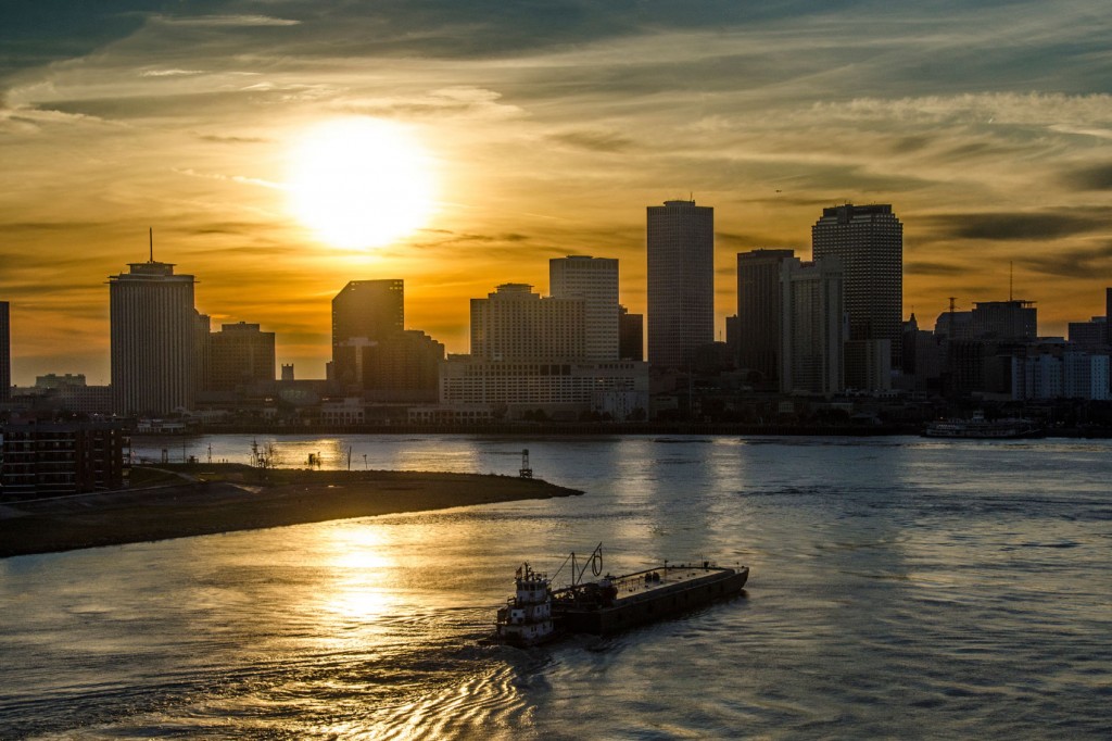 The sun sets over the Mississippi River in New Orleans.