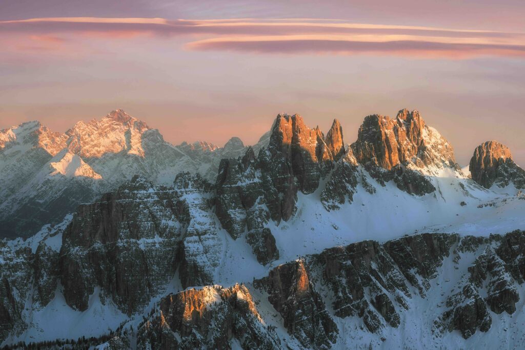 close up of European landmark the Dolomites in Italy, can see the mountain range against a cloudy backdrop. Snow visible. 