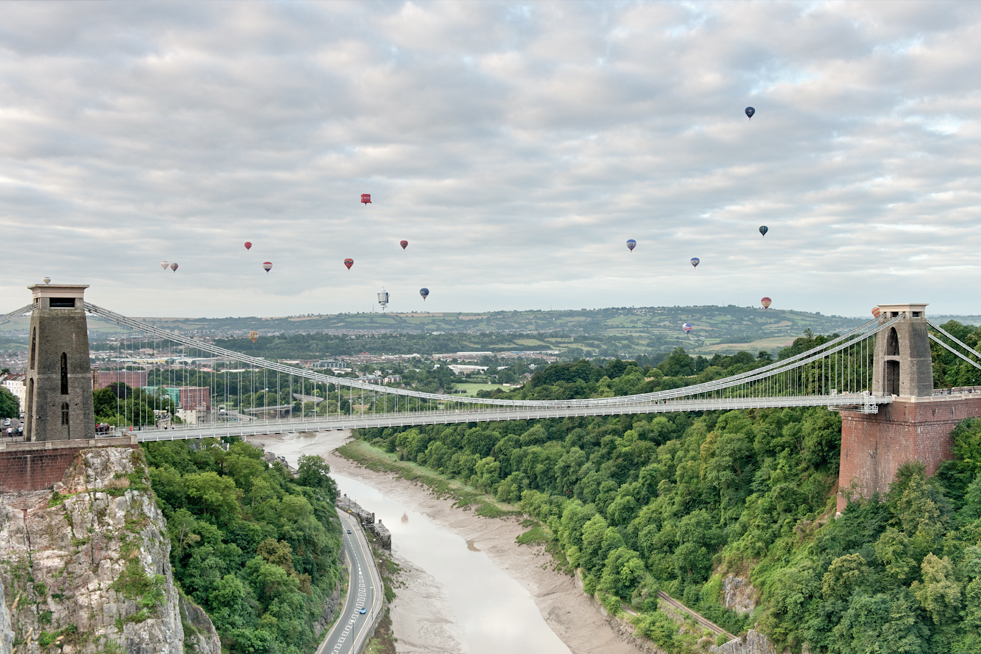 Colourful hot air balloons floating over Clifton Bridge in Bristol, England.