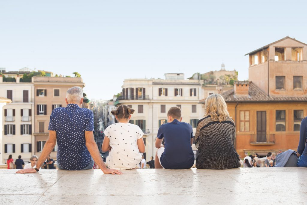 family of four sitting on steps in rome