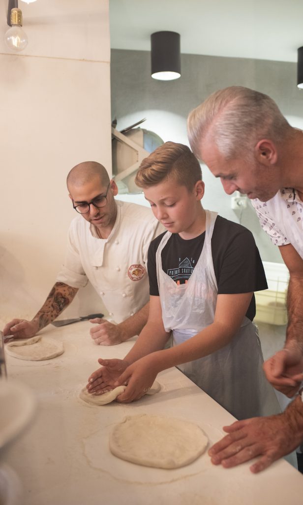 father and son making pizza
