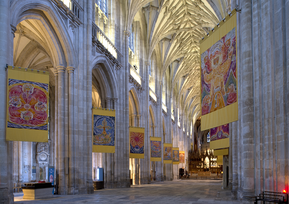 A large cathedral with a lot of paintings hanging on the walls in Winchester, England's, cathedral.
