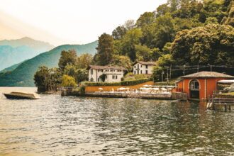 A lakeside view of Lenno, trees cascading downwards into the lake
