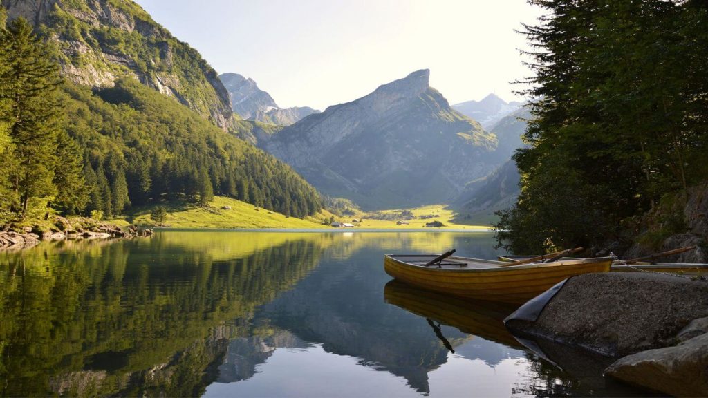 row boat on lake mountains switzerland