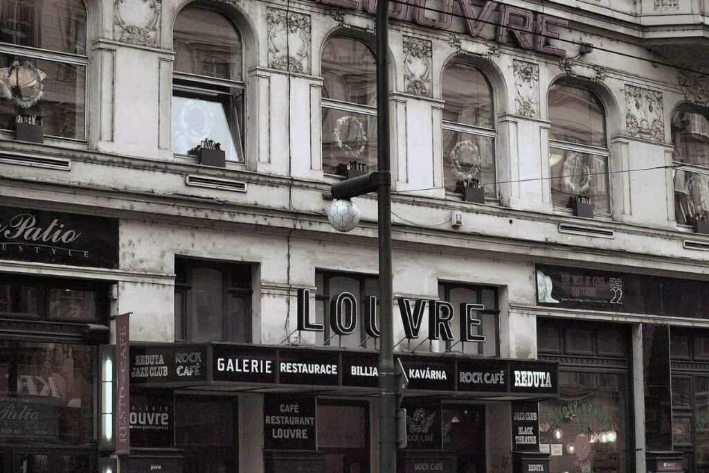 Sepia image of Cafe Louvre in Prague, old building with 'Louvre' sign in the middle.