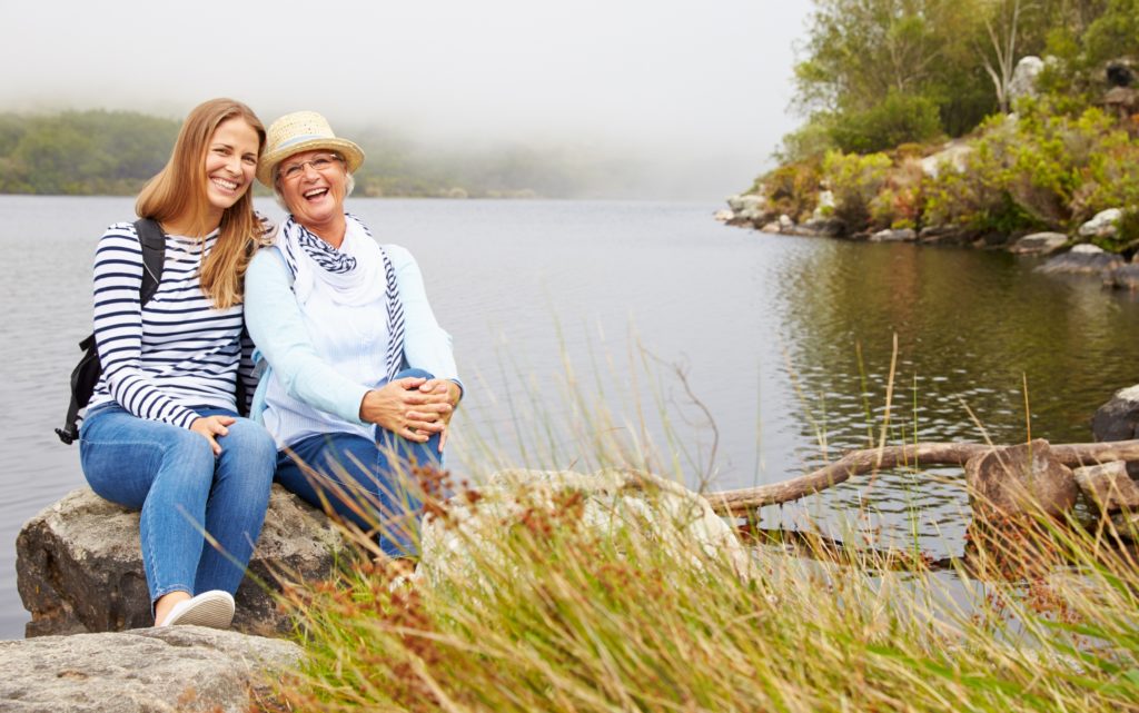 Mum and daughter enjoy a rest by a lake