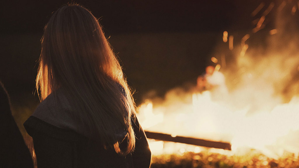 standing in front of a fire