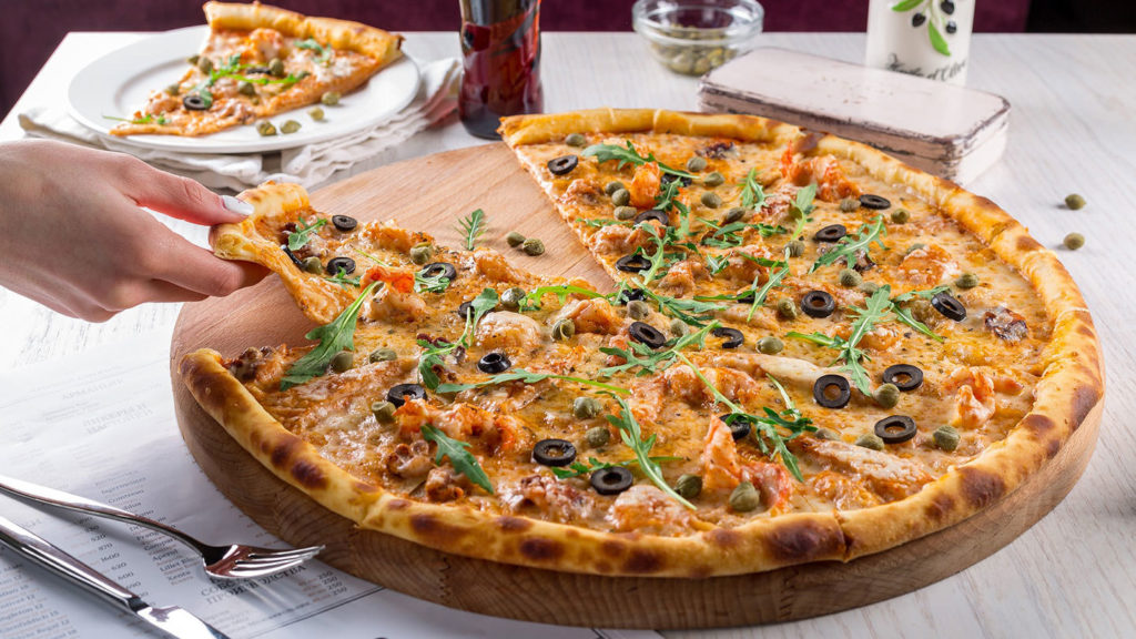 Pizza being sliced  at Vaduz restaurants, cafés and bars