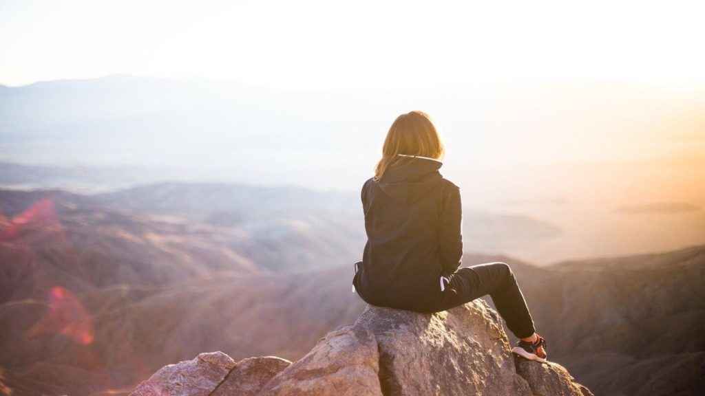 woman sitting on mountain love of travel