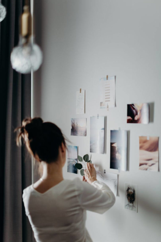 woman hanging photos souvenir collection