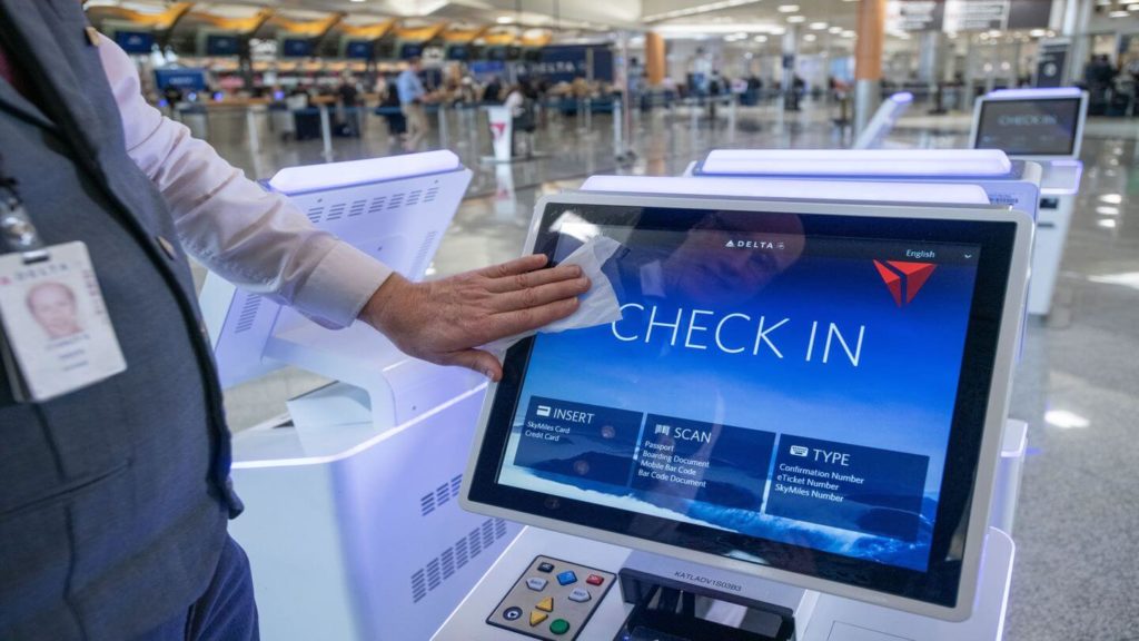 Delta staff wiping down check in kiosks at airport how do airlines clean the plane