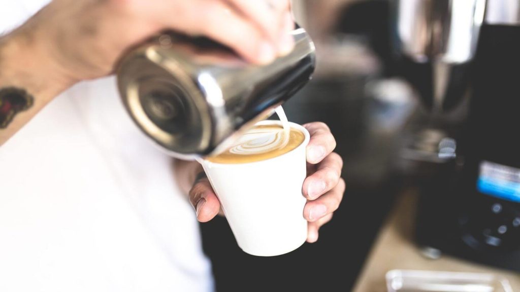 hand pouring milk into coffee Melbourne's coffee culture