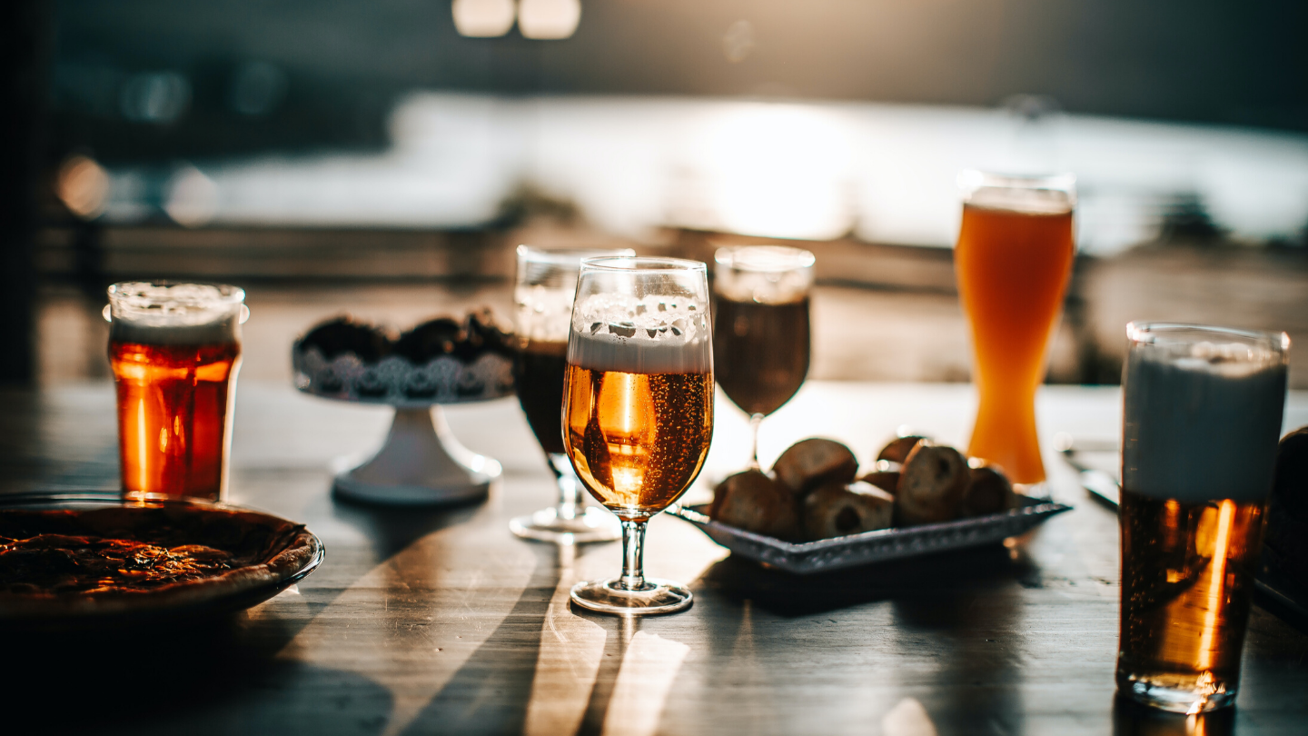 Pints of beer on a table surrounded by food