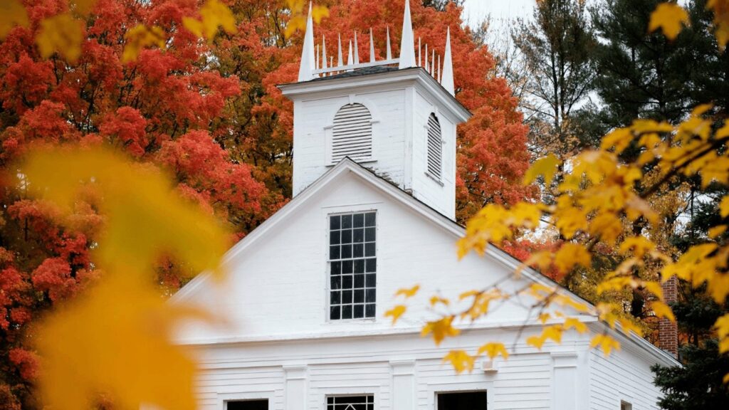 Fall foliage on white church in New England.