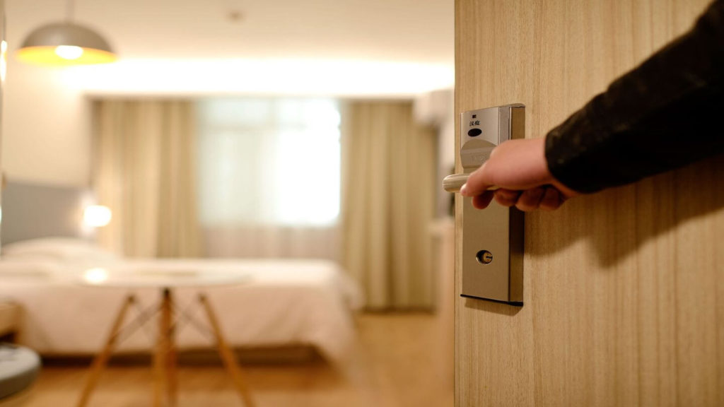hand opening door to hotel room