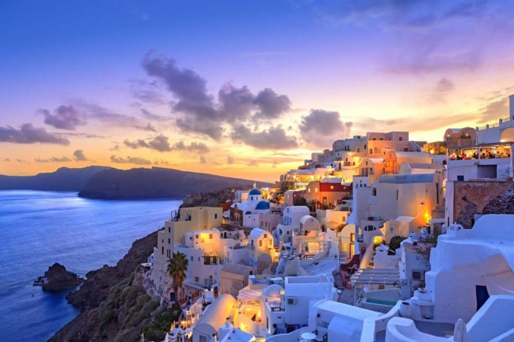 clifftop village in Santorini illuminated at sunset