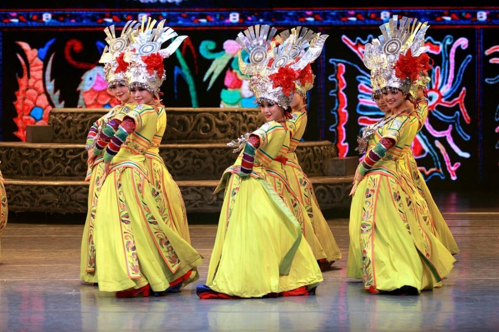 traditional dancers in bright costumes China travel guide
