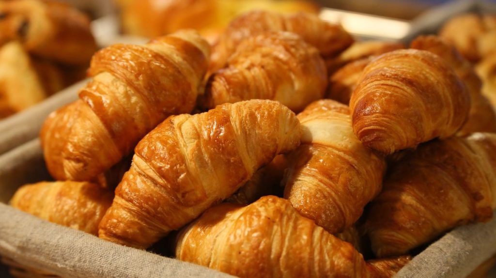 A basket of freshly baked, golden-brown croissants, considered among the best in Paris.