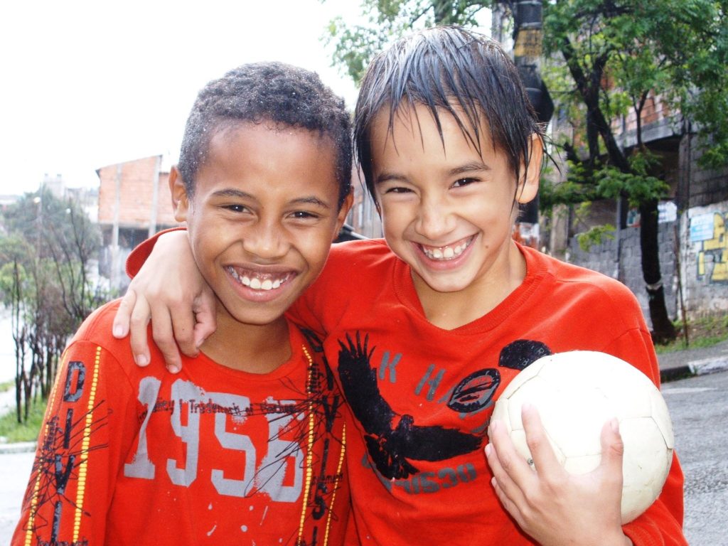 Young children posing with soccer or football in Brazil