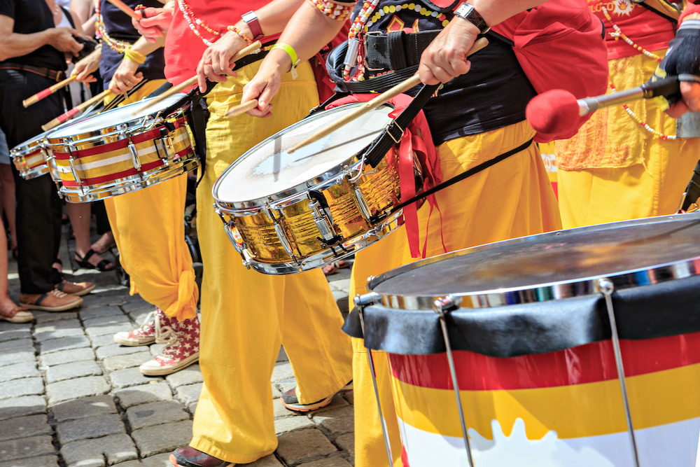 Samba school musicians with drums and colourful costumes performing at Rio Carnival. 