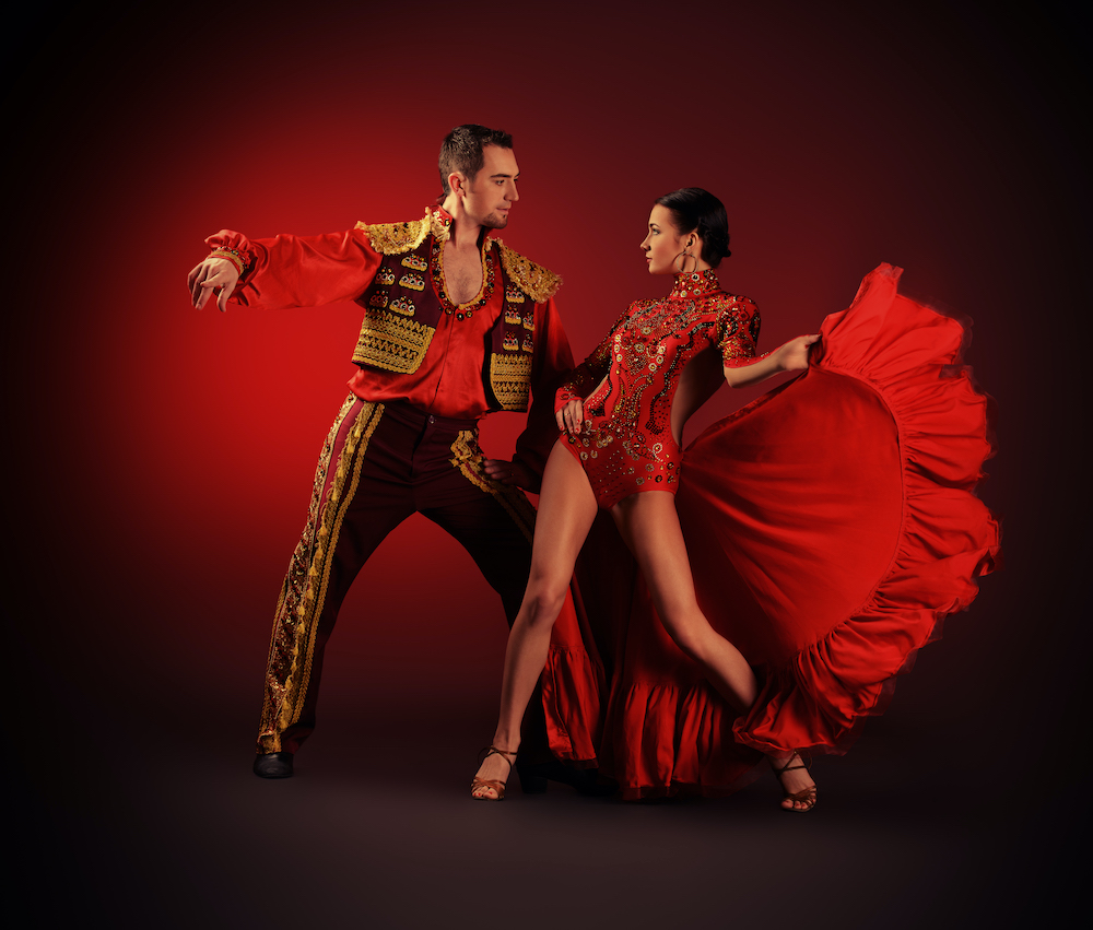 Professional rumba dancers posing the red costumes.
