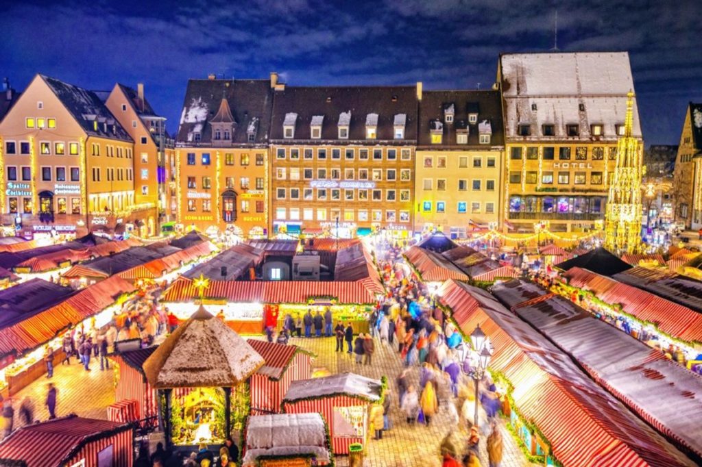 A vibrant evening at a bustling Germany's Christmas markets in a traditional European town square.