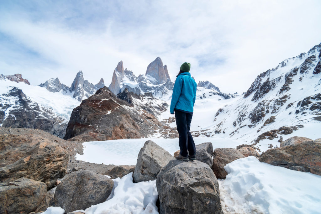 Woman standing on a rock looking up the mountains in Patagonia
