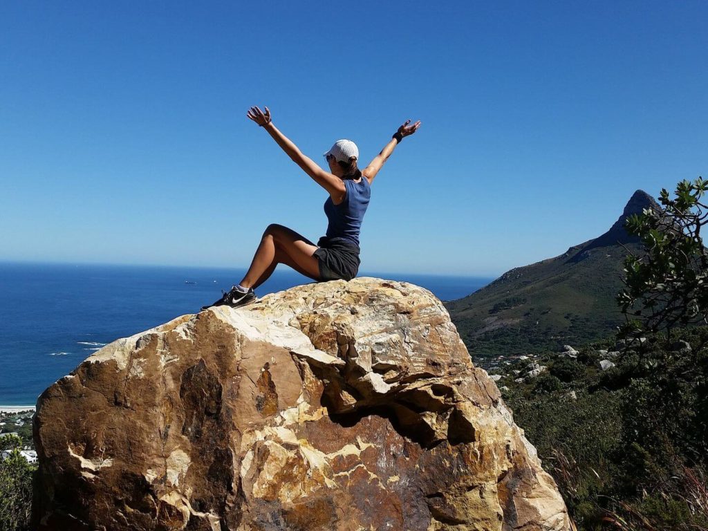 woman sitting on a rock on a mountain top South Africa