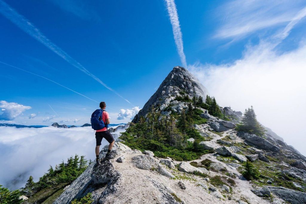 man hiking up a mountain peak