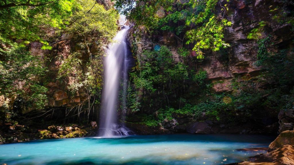 shimmering blue waterfall green jungle Costa Rica
