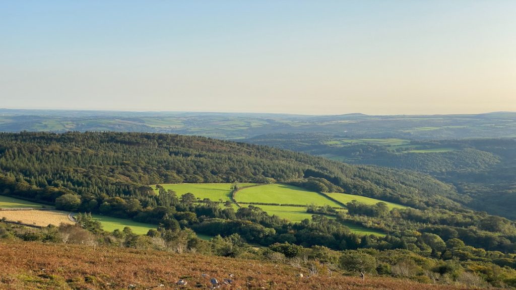 Rolling hills and expansive countryside in Cornwall and Devon bathed in soft sunlight.