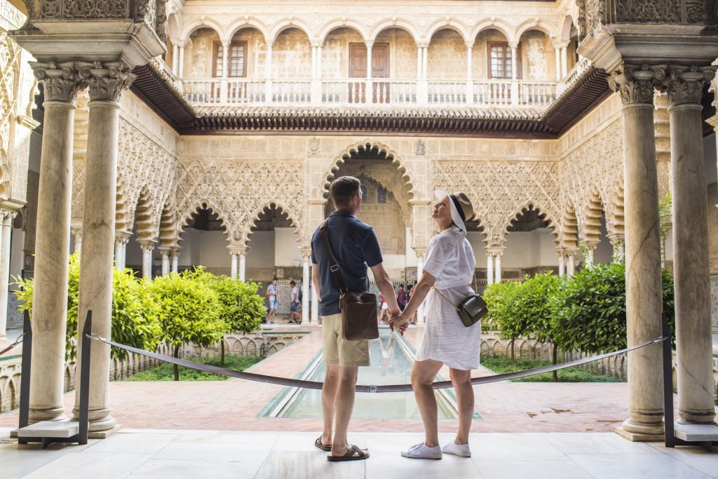 couple holding hands admiring architecture in Spain
