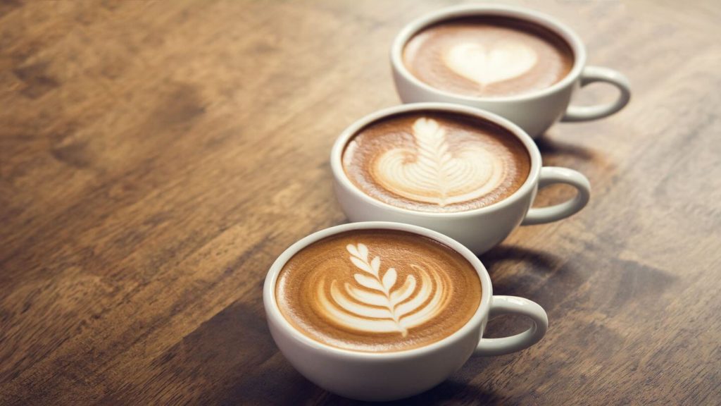 three coffees in mug with latte art