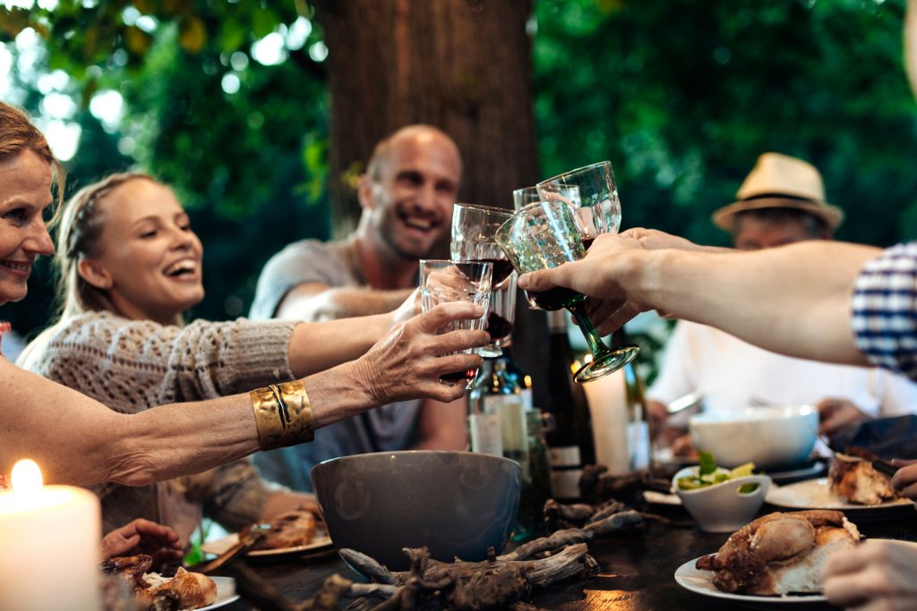 group of travellers sharing a meal and toasting together