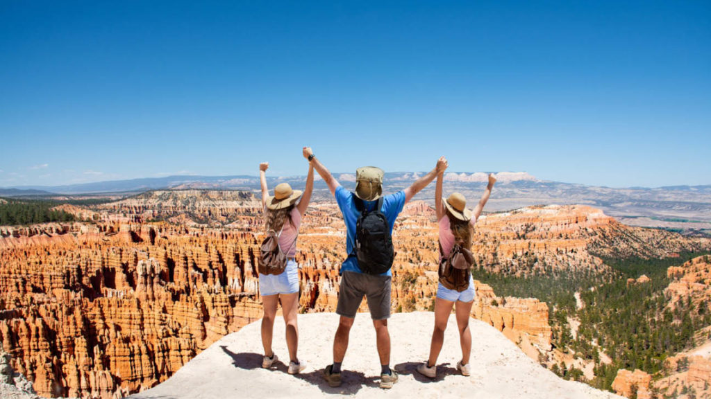 family of three holding hands looking out over Bryce Canyon National Park USA