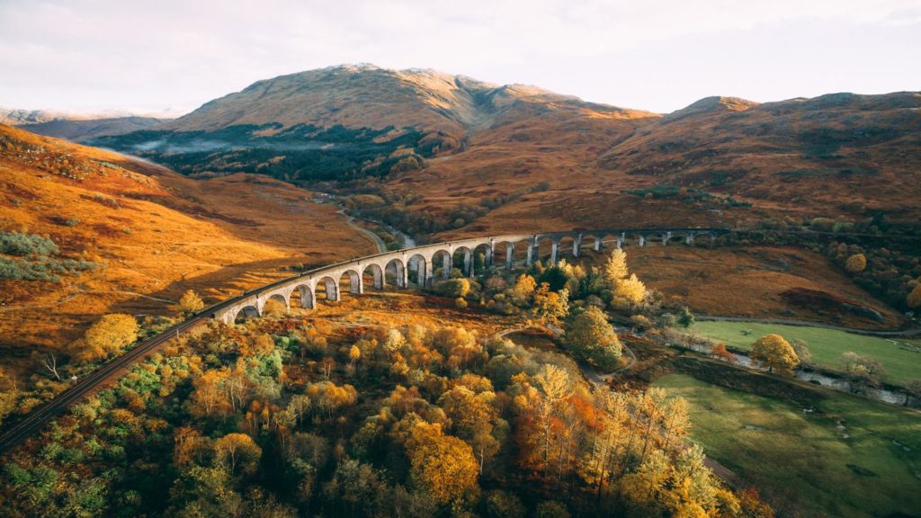 Glenfinnan Viaduct arches through the Scottish Highlands in autumn