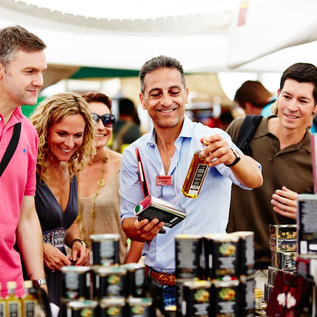 Trafalgar travel director and guests looking at products in a market
