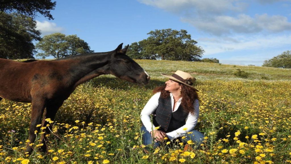 woman smiling at a horse in a flower field Spain Trafalgar trips