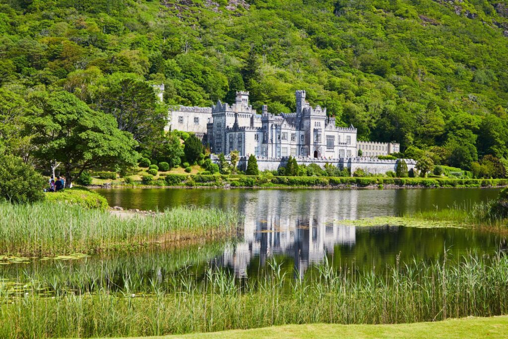 Daytime picture of Kylemore Castle by a lake, one of the best castles to visit in Ireland