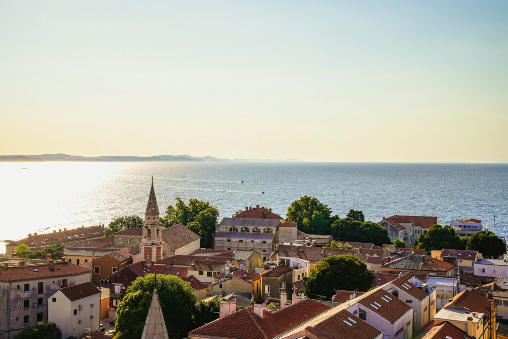 Boats in the distance sail passed the Old Town of Zadar, Croatia. 