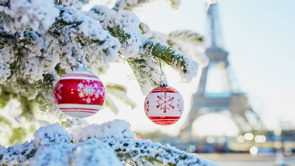 Red and white baubles on a Christmas tree with the Eiffel Tower in the background in Paris, France