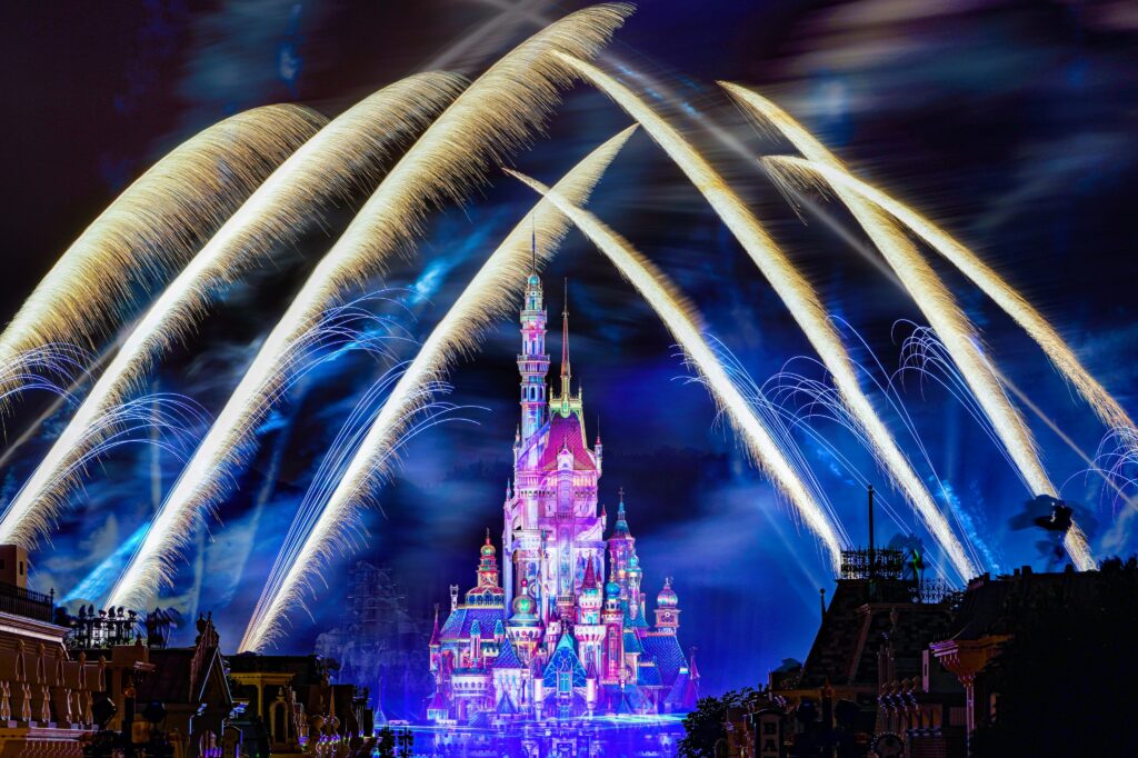 Disneyland Hong Kong's castle flanked by fireworks shooting into the night sky.