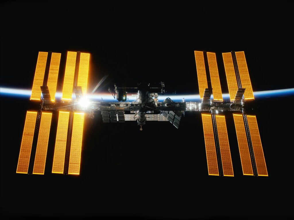 The International Space Station in orbit against the vast blackness of space.